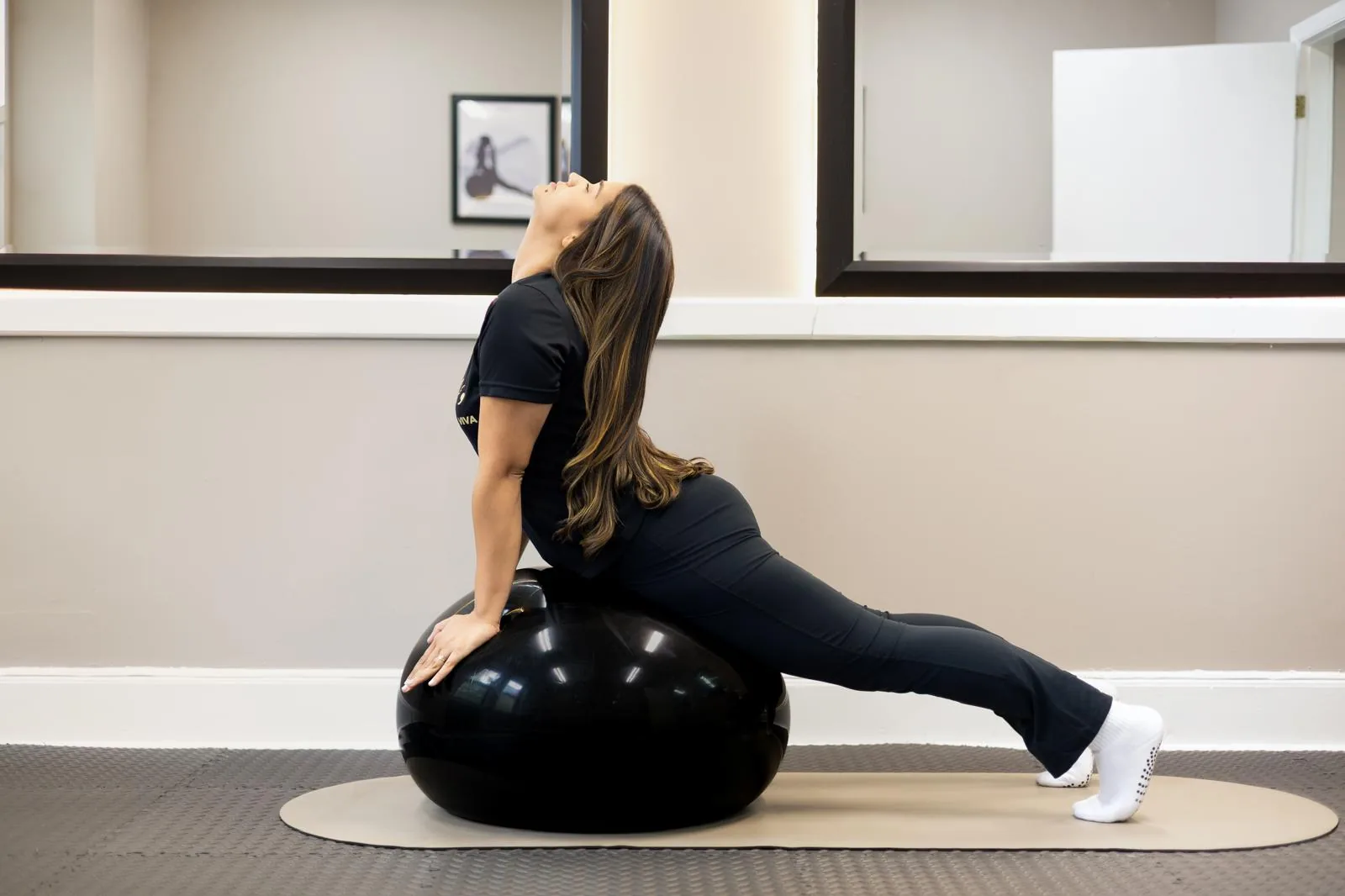 Back extension stretch over an exercise ball on a Pilates mat