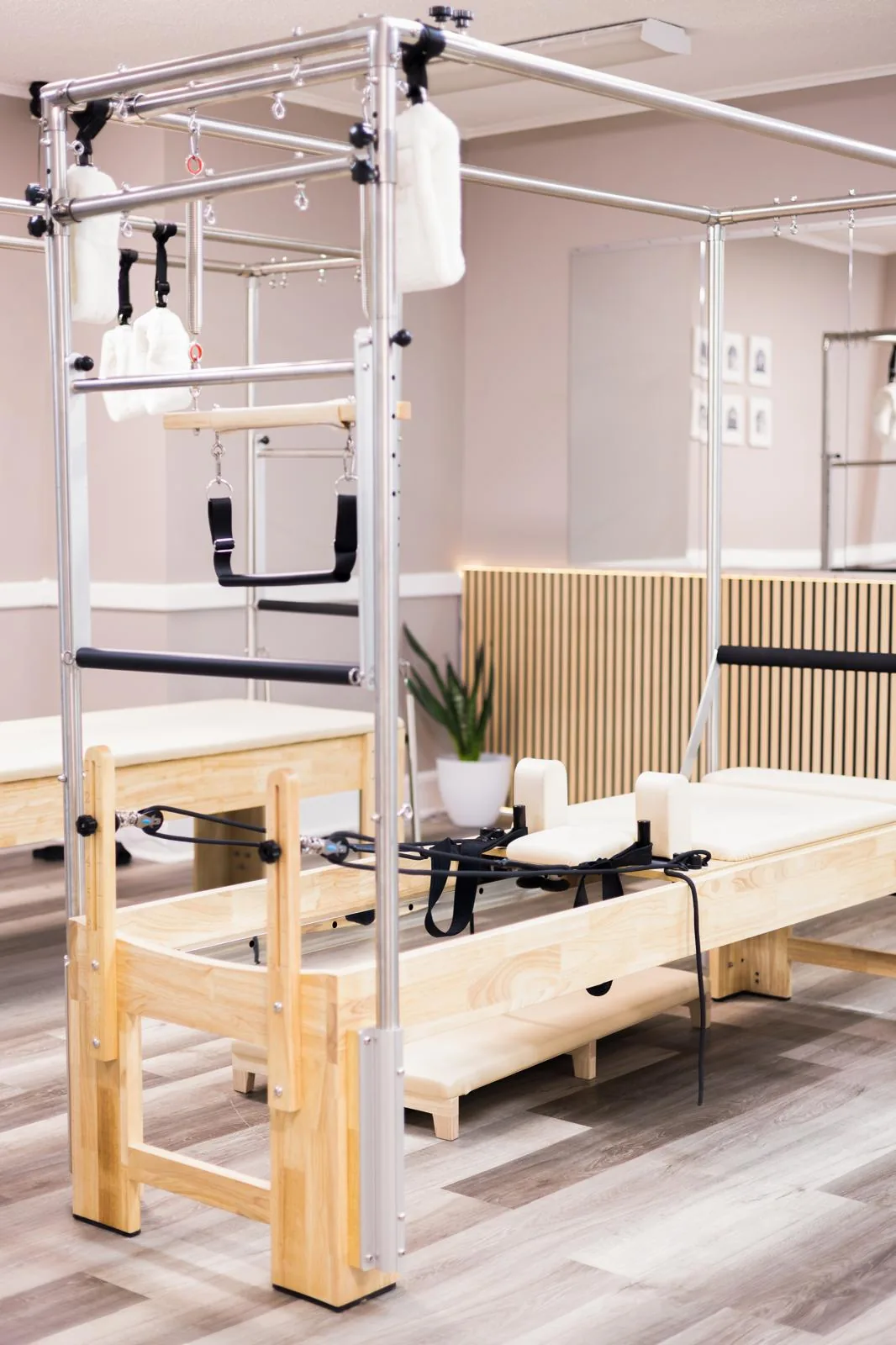Cadillac trapeze table and Reformer in the bright main room of Inspire Pilates Studio