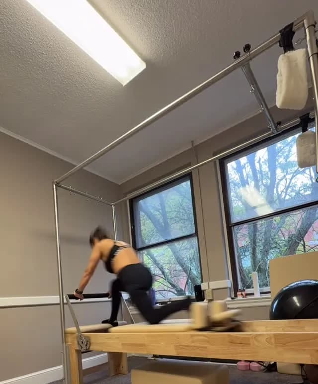 Client doing a kneeling exercise on the Reformer during a private Pilates session in Lowell